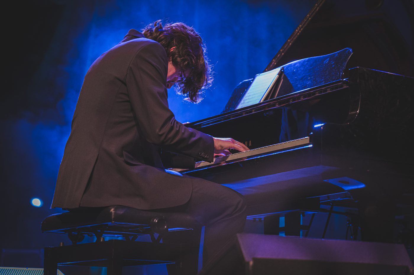 Ilirian Patrício Ahmeti performing under blue stage light