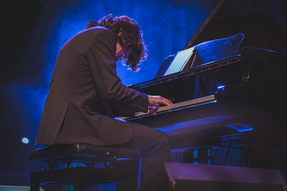 Ilirian performing under blue stage light